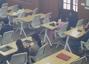 The lady in the pink dress remove heels in classroom