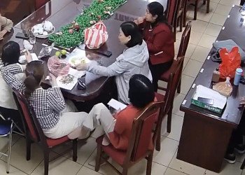 The teacher in nylon sit down remove her white heels talk with her co-workers