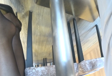 Salesgirl in black nylon dangling under the table