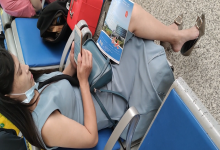 Lady bare feetdangling shoeplay when waiting for the train in railway station lounge