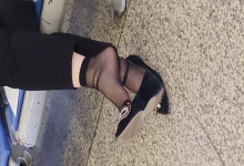 The middle-age lady in black nylon dangling shoeplay  when waiting for a train 
