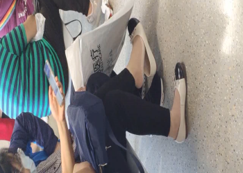 The  lady dangling shoeplay when line up in the waiting hall 144