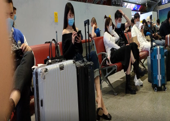 The lady dangling shoeplay when waitting for a train 47