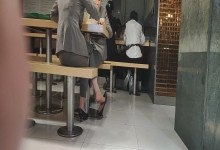 The girl in white nylon great dangling shoeplay under the table when having lunch 