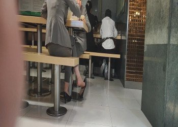 The girl in white nylon great dangling shoeplay under the table when having lunch 