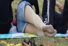 The girl remove shoes relax her sexy nylon feet on the grass