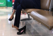 Airline stewardess remove heels relax her tired feet