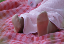 The girl sat on the lawn relax her feet