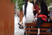 The middle-age lady dangling shoeplay on park bench