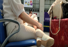 The  lady dangling shoeplay when line up in the waiting hall 107
