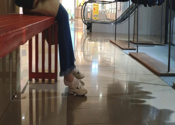 The lady sat down in a chair and relaxed her tired feet