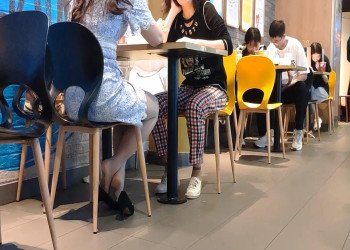 The hot girl dipping shoeplay under the table when having lunch