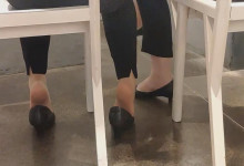 The lady diping shoeplay under the table when having lunch
