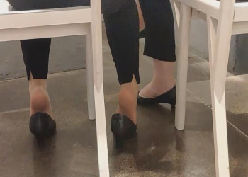 The lady diping shoeplay under the table when having lunch