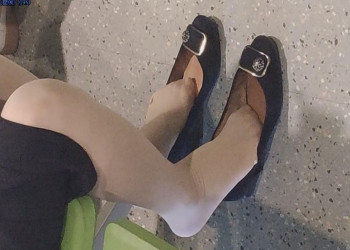 The middle age lady dangling shoeplay when waiting for a call