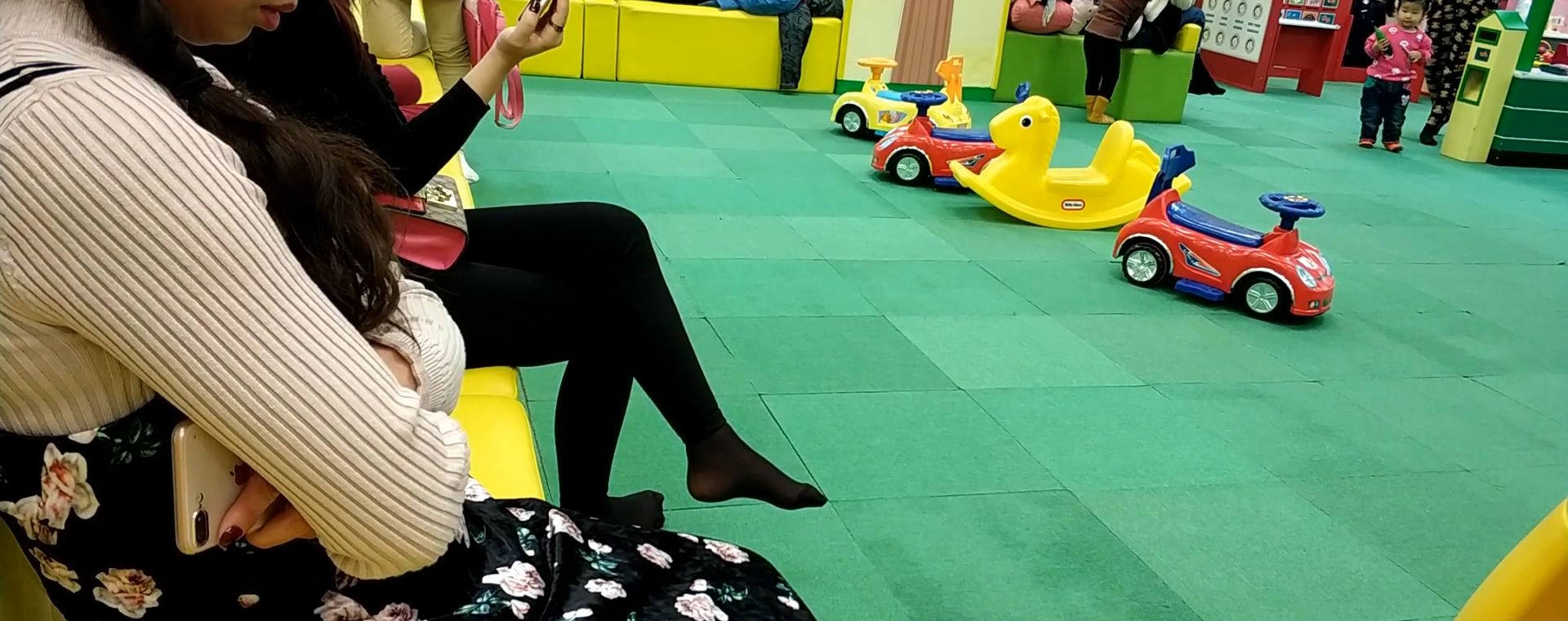 Lots of mother&#039;s black nylon feet from kids activity centre