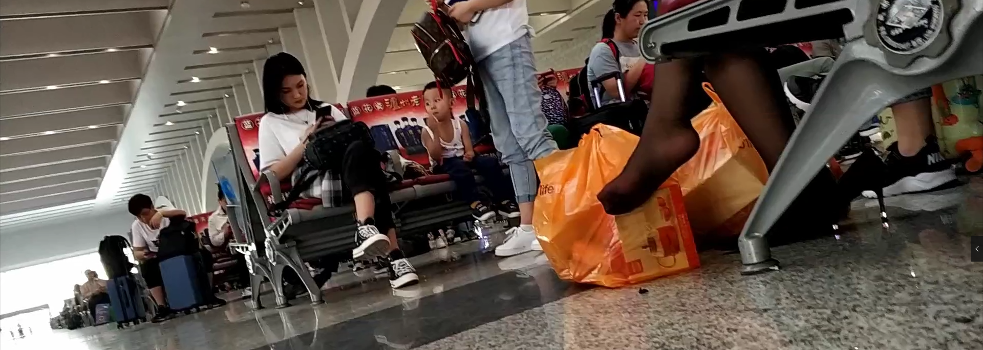 Lady relax her tired feet when waiting for the train in railway station lounge 4