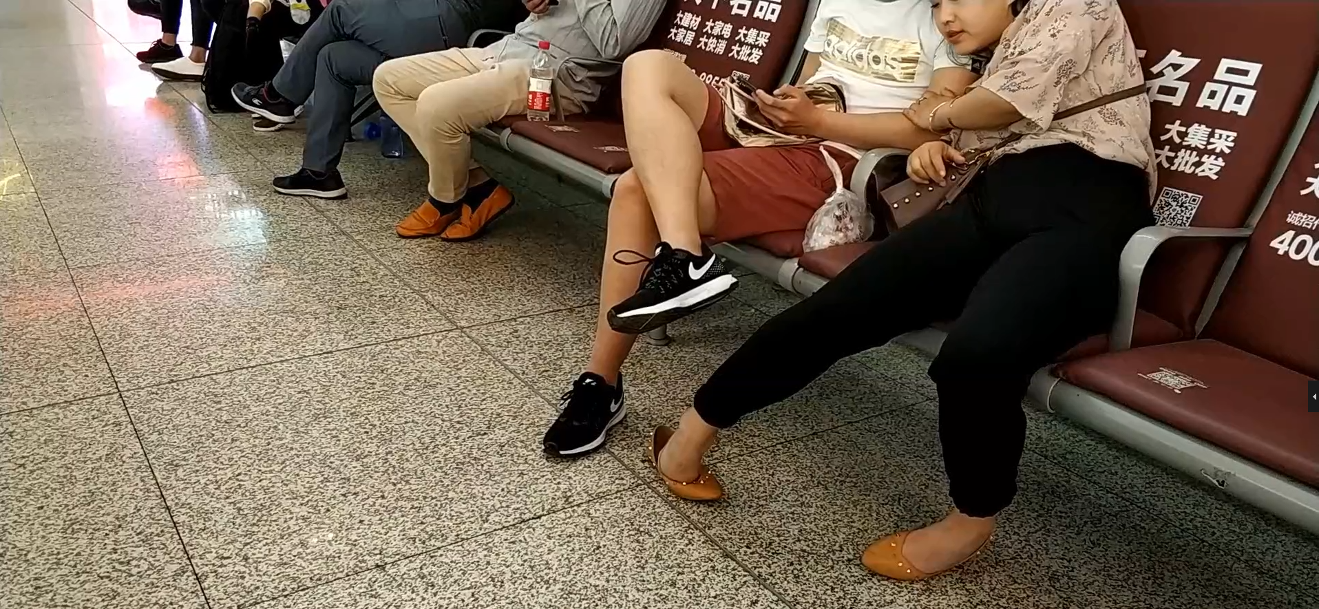 Lady relax her tired feet when waiting for the train in railway station lounge 7
