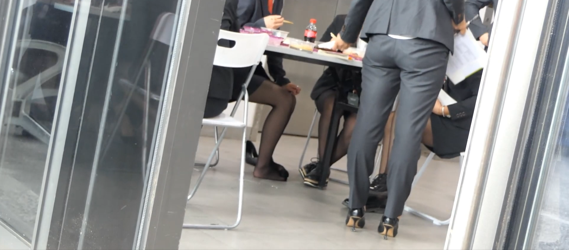 Lunch time hostess&#039;s black nylon feet under the table