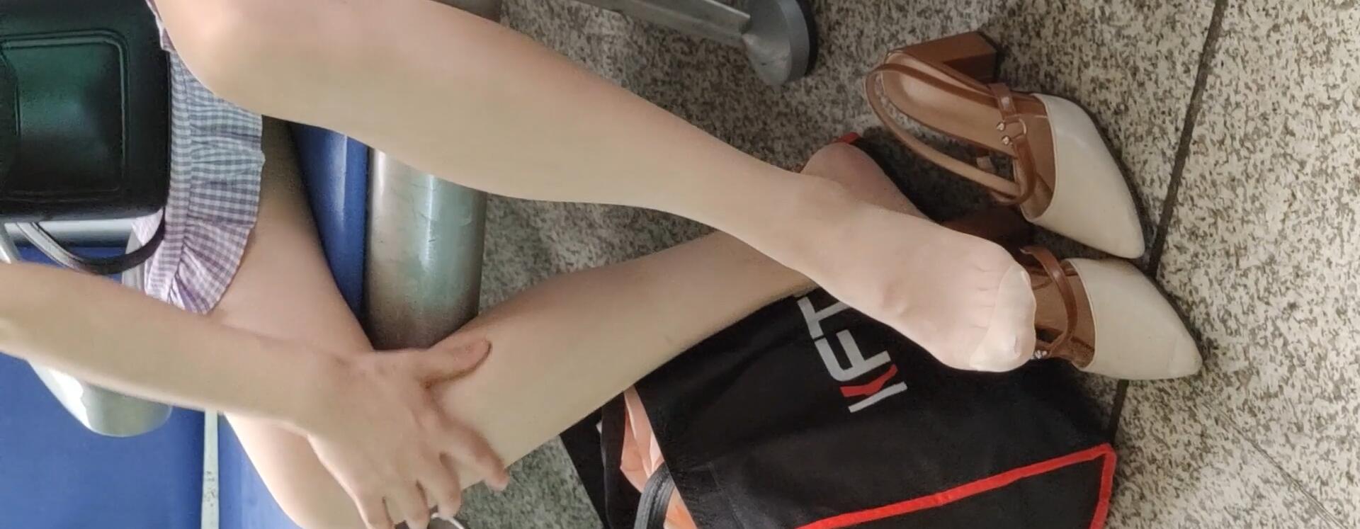 Lady remove shoe and relax her tired feet on the chair when waiting for a train 27