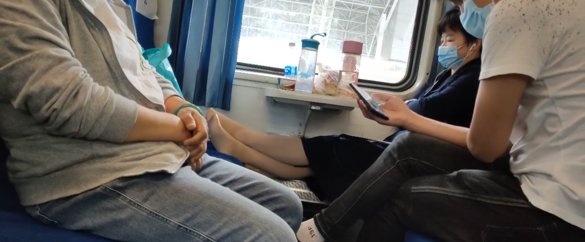The lady take off her shoes on the train