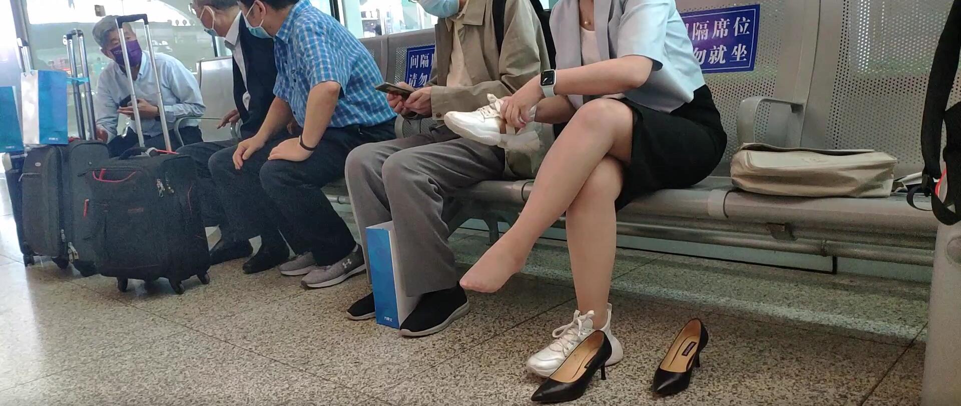 The lady remove shoes relax her tired feet when waitting for a train 49