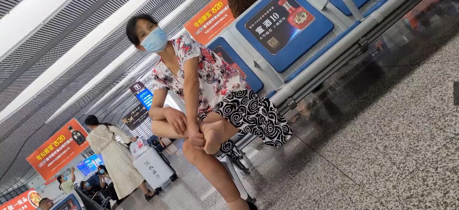 The middle-age lady relax her tired feet when waiting for a train 3