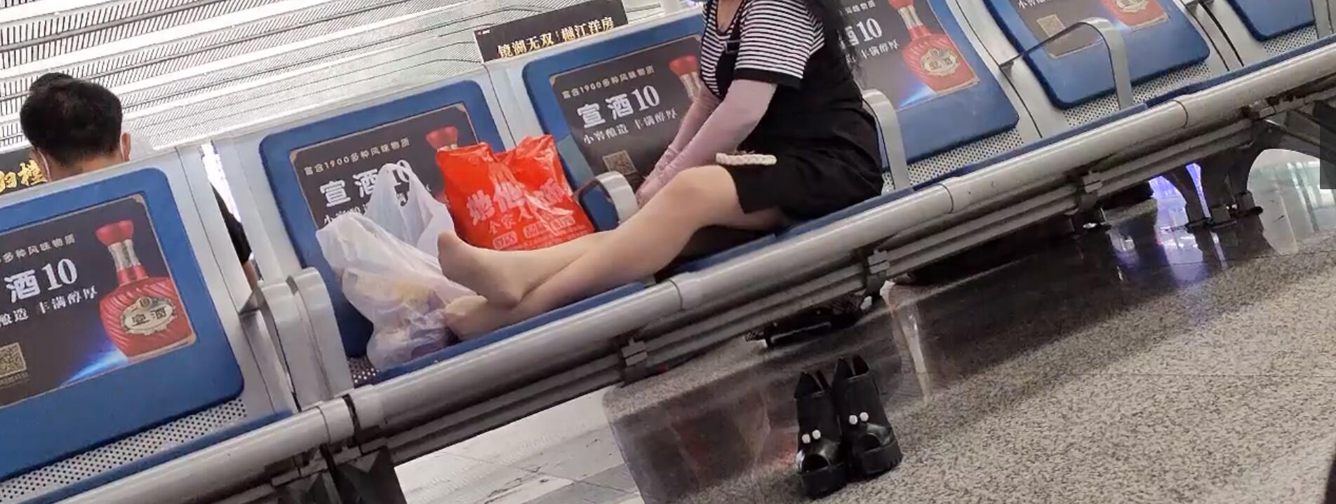 The old lady relax her tired feet when waiting for a train 