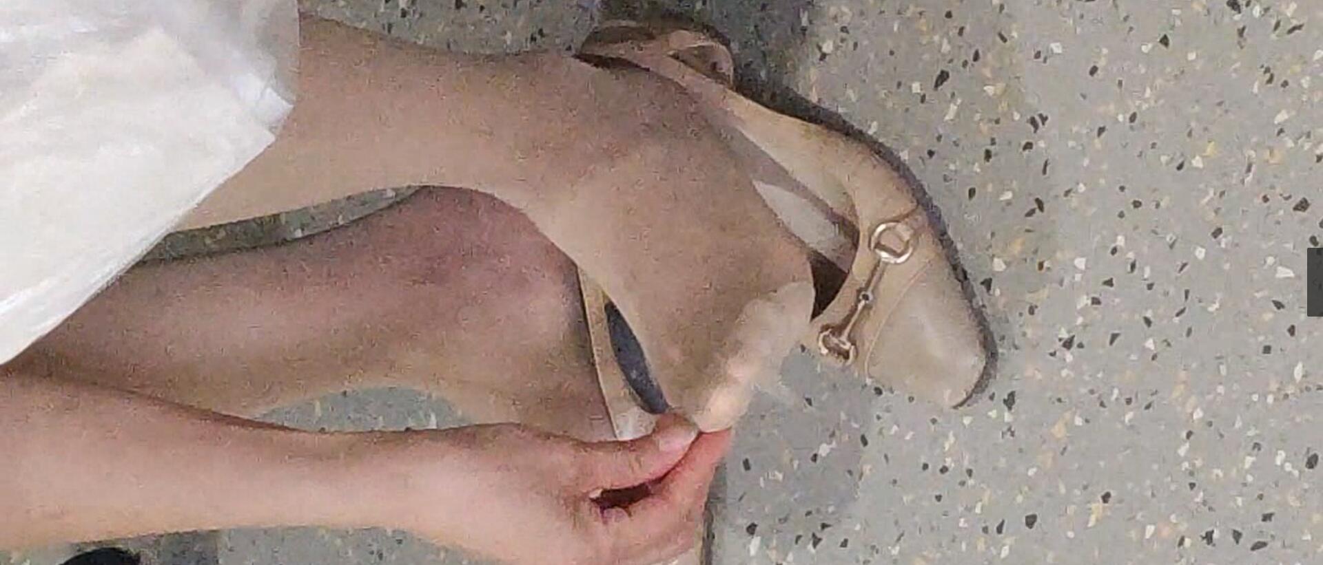 The lady relax her tired feet when line up in the waiting hall 109