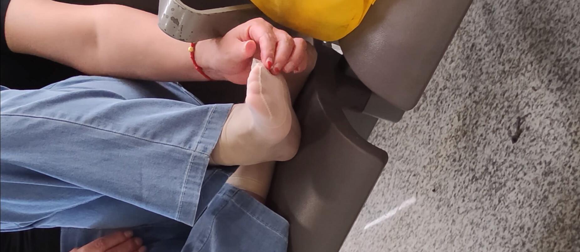 The lady remove shoes relax her tired feet when waitting for a train 70