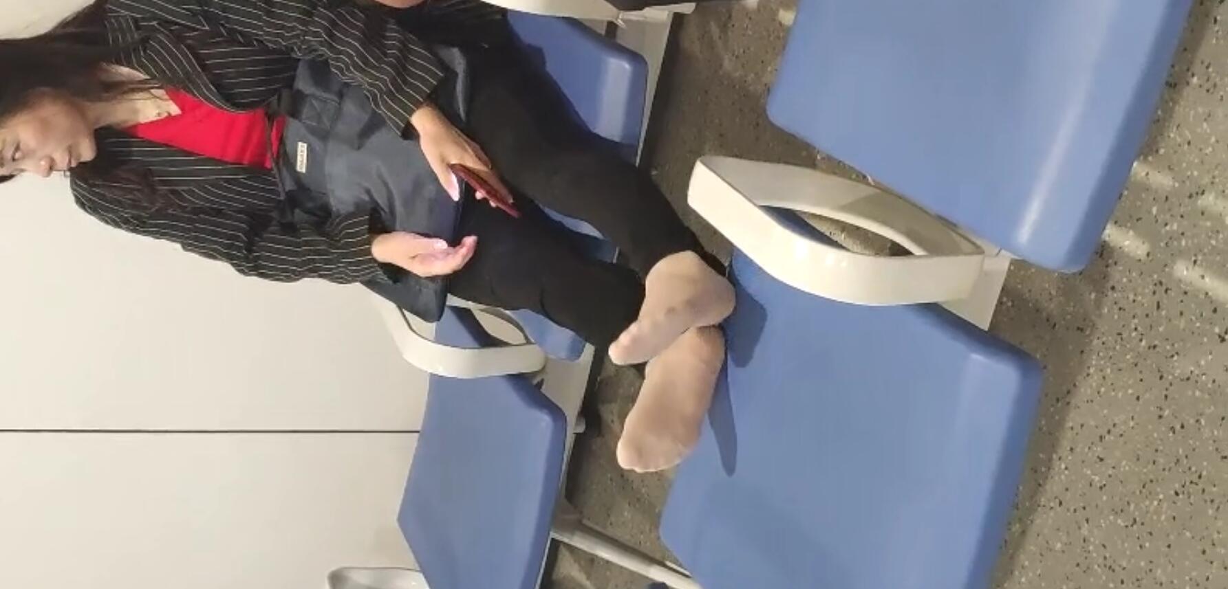 The lady relax her tired feet when line up on the waiting hall 264