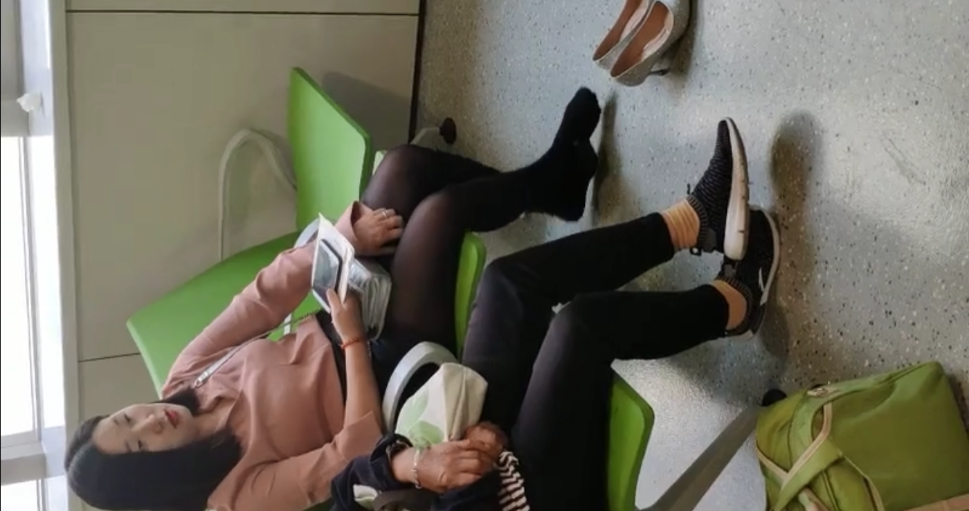 The lady relax her tired feet when line up on the waiting hall 270