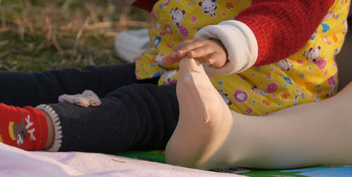 The lady remove heels relax her feet on the grass