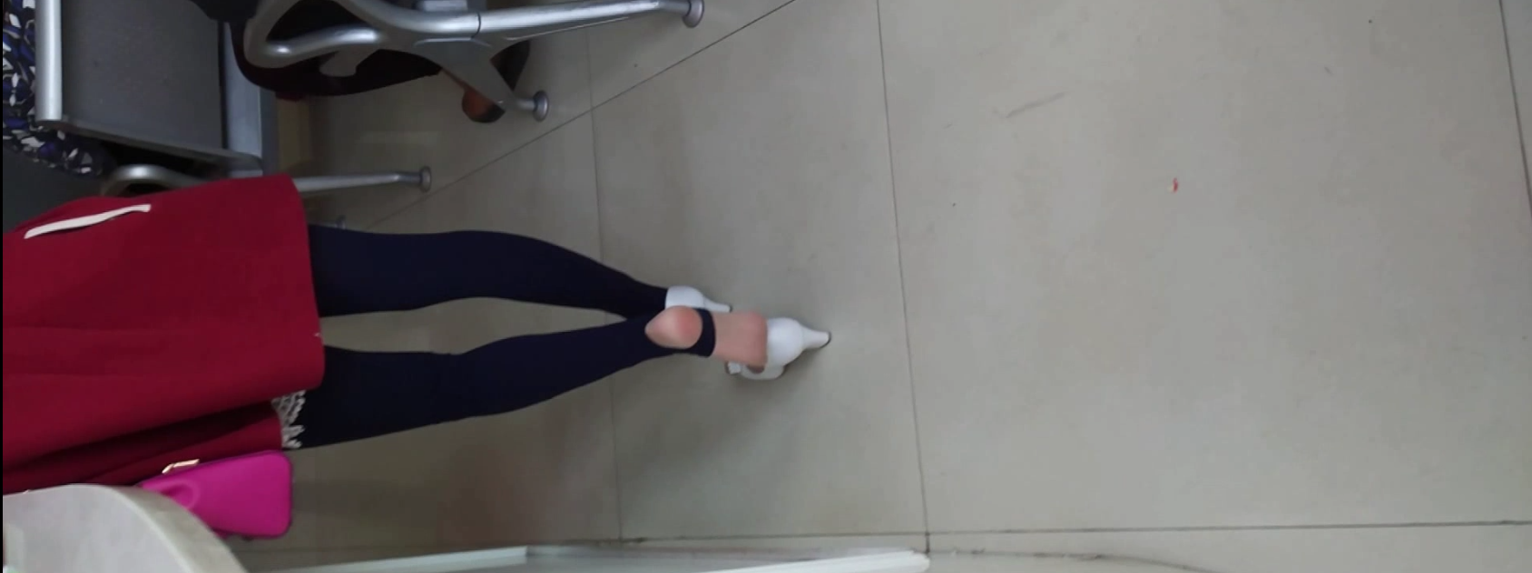 Lady great dangling shoeplay when waiting for the train in railway station lounge 16