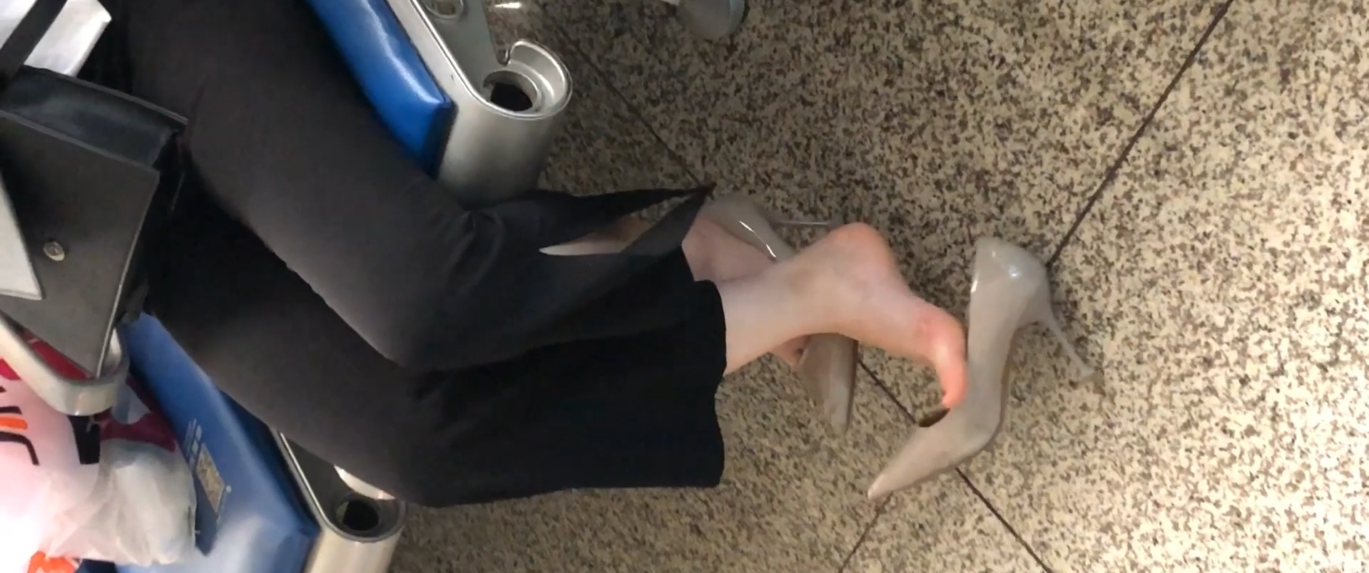 Lady dangling shoeplay when waiting for a train 33