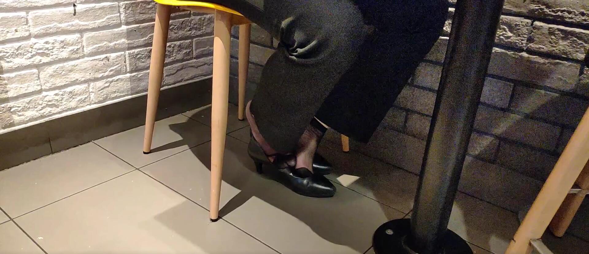 The lady dangling shoeplay under the table when having lunch 22