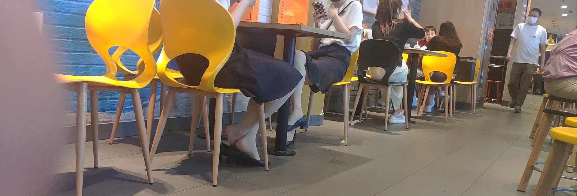The girls dipping shoeplay under the table when having lunch 4